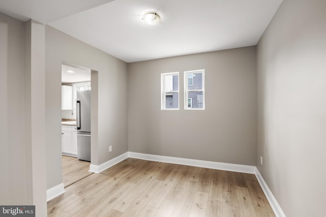 spare room with light wood-style flooring and baseboards