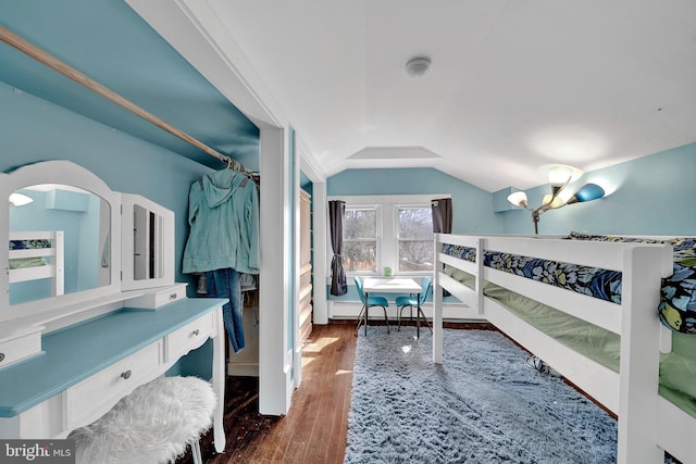 bedroom featuring vaulted ceiling, wood finished floors, and an inviting chandelier