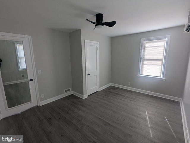 unfurnished bedroom featuring dark wood-style floors, ceiling fan, visible vents, and baseboards