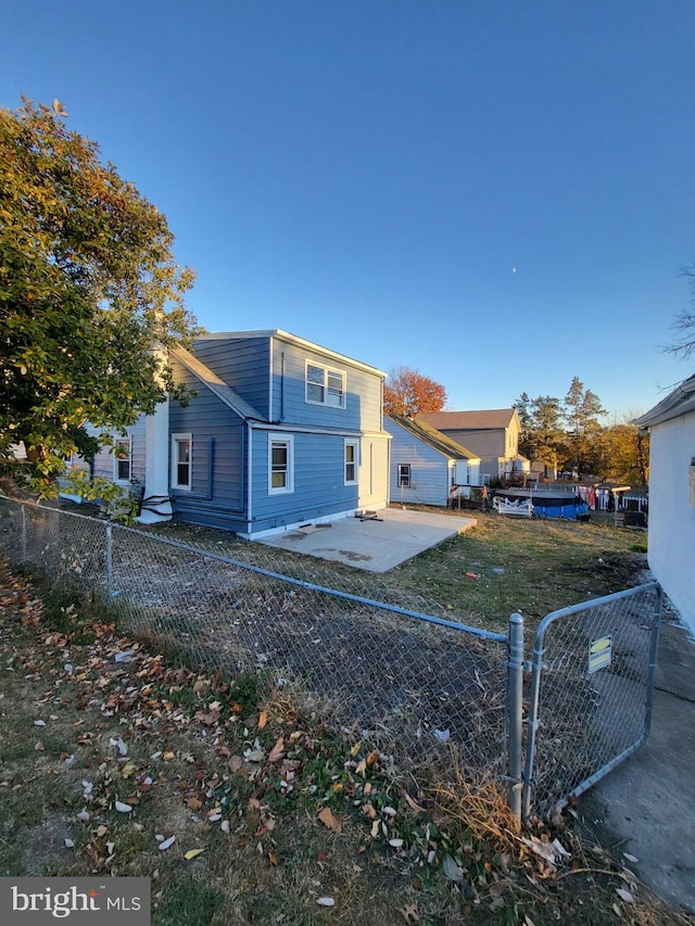 rear view of property featuring fence private yard, a patio area, and a lawn