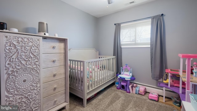 carpeted bedroom with a crib, a baseboard radiator, and visible vents