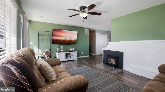 living room with ceiling fan, visible vents, baseboards, and dark wood-type flooring