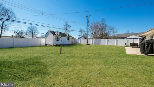 view of yard with a patio area, a fenced backyard, and an outdoor structure