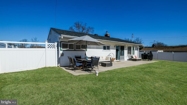 rear view of property with a lawn, a patio area, and a fenced backyard