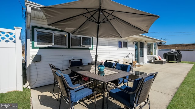 view of patio with outdoor dining space and fence