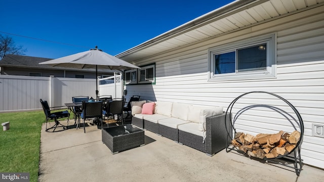 view of patio / terrace featuring fence, an outdoor living space, and outdoor dining space