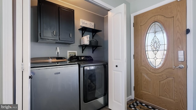 clothes washing area with independent washer and dryer and cabinet space