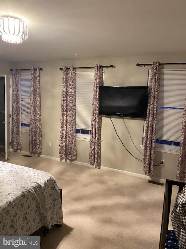 carpeted bedroom featuring visible vents and baseboards