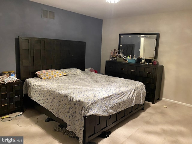 bedroom featuring baseboards, visible vents, and light colored carpet