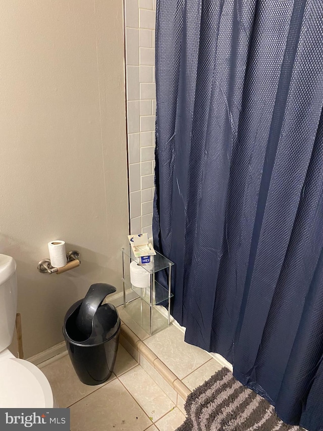 bathroom featuring toilet and tile patterned flooring