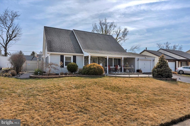 view of front of home with a front lawn, fence, a garage, and a shingled roof