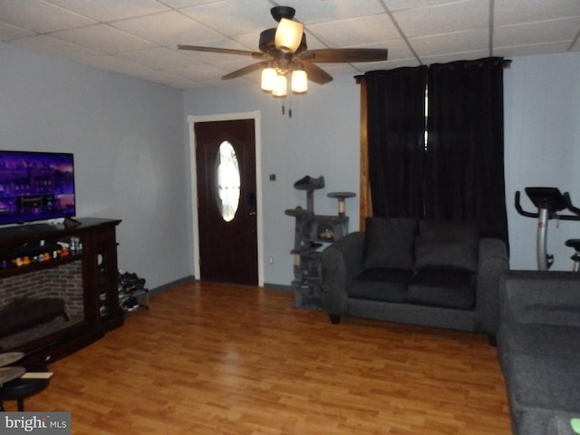 living area featuring a paneled ceiling, ceiling fan, and wood finished floors