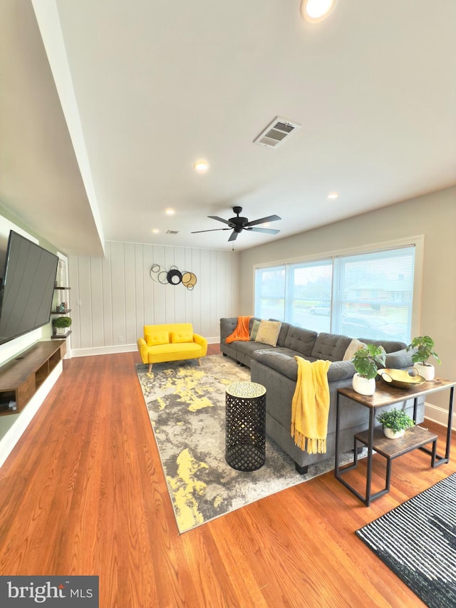 living room with recessed lighting, wood finished floors, visible vents, and baseboards