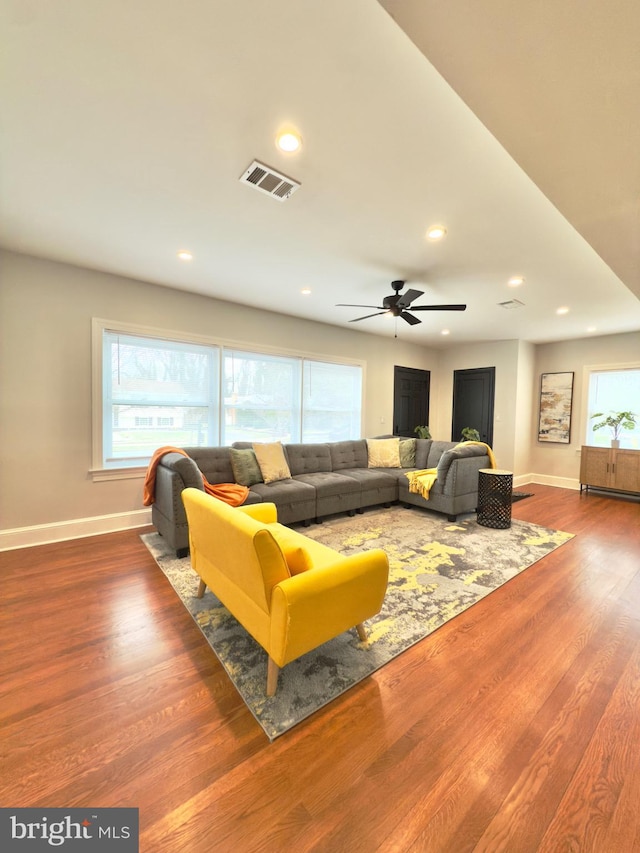 living area featuring visible vents, recessed lighting, baseboards, and wood finished floors