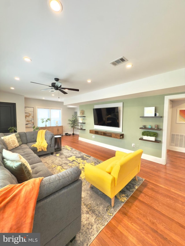 living area with recessed lighting, wood finished floors, visible vents, and baseboards