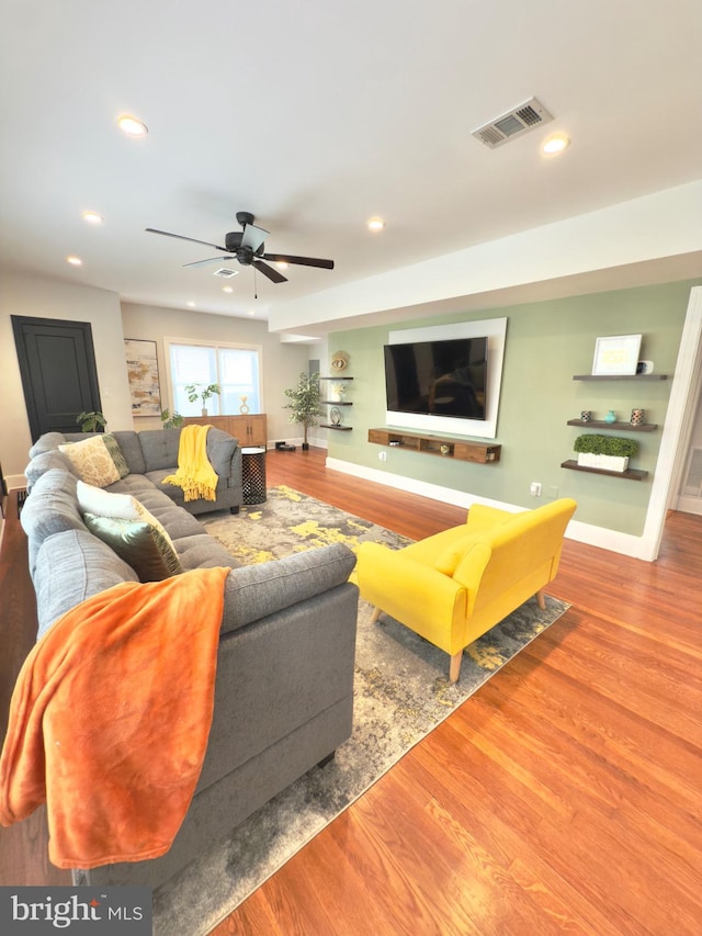 living area with recessed lighting, wood finished floors, and visible vents