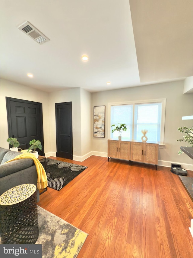 living room featuring recessed lighting, visible vents, baseboards, and wood finished floors