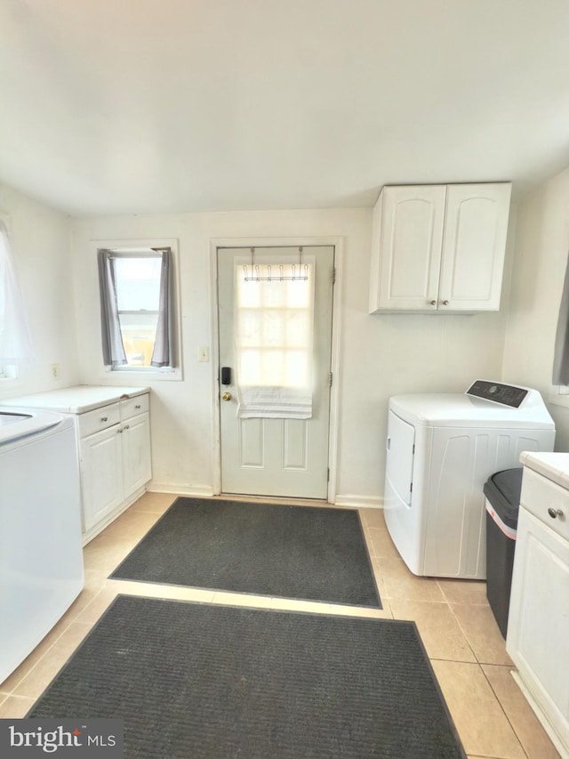 laundry area with washer and dryer, cabinet space, and light tile patterned flooring