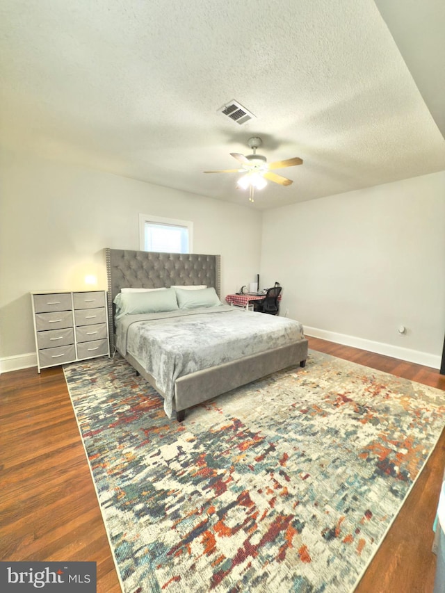 bedroom with visible vents, baseboards, and dark wood-style flooring