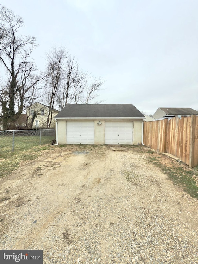 detached garage featuring fence