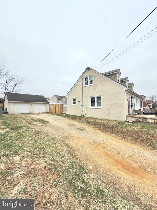 view of home's exterior with fence, a garage, and stucco siding