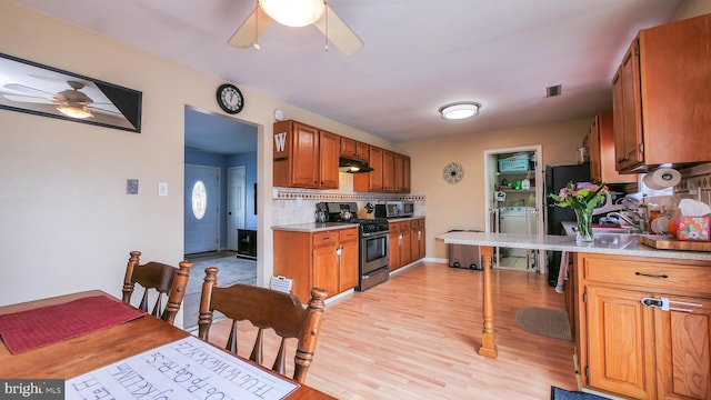 kitchen with brown cabinetry, appliances with stainless steel finishes, and light countertops