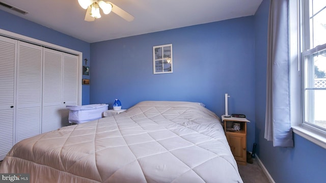 bedroom with a ceiling fan, baseboards, visible vents, and a closet