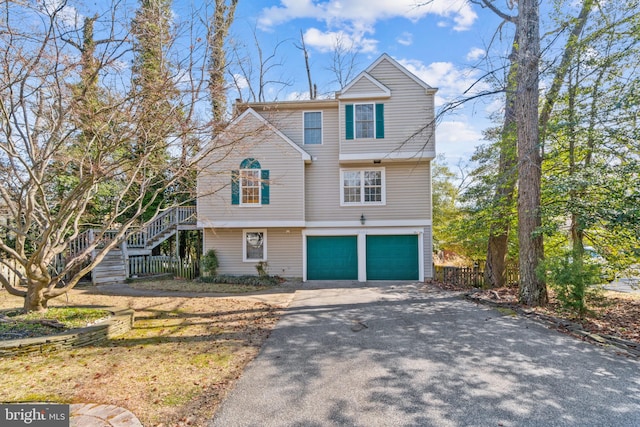 view of front of home with a garage, driveway, and stairway