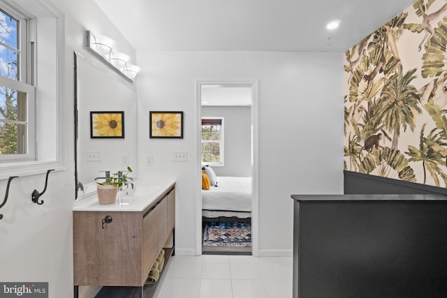 bathroom featuring ensuite bathroom, baseboards, vanity, and tile patterned floors