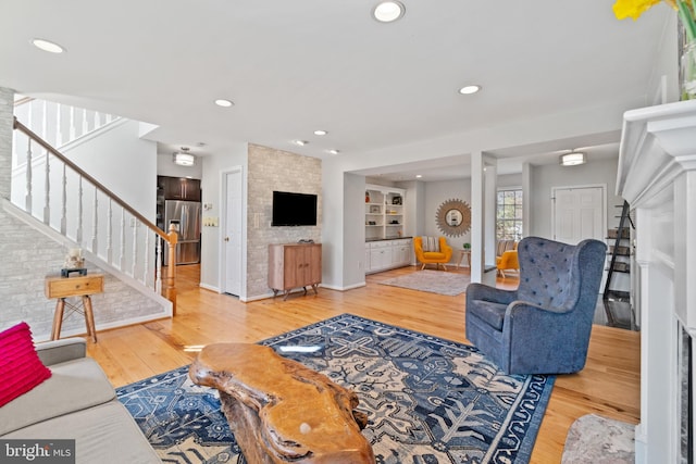 living area featuring recessed lighting, wood finished floors, and stairs