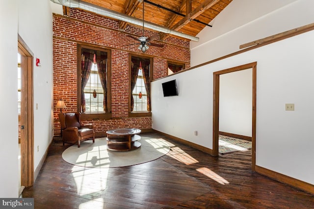 unfurnished room featuring hardwood / wood-style floors, wood ceiling, brick wall, high vaulted ceiling, and baseboards