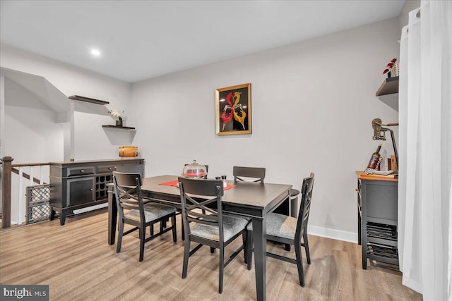 dining space featuring baseboards and light wood finished floors