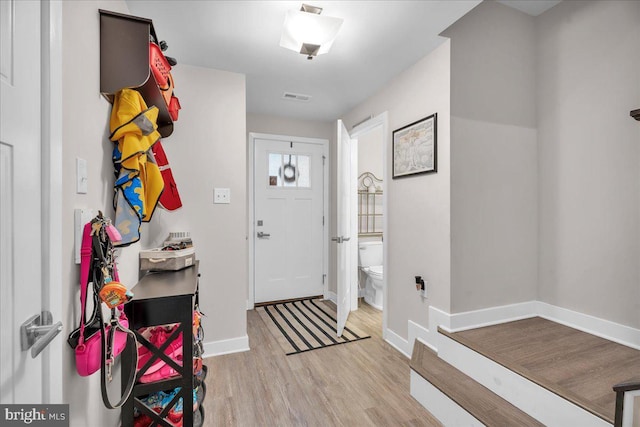 entryway featuring visible vents, baseboards, and wood finished floors