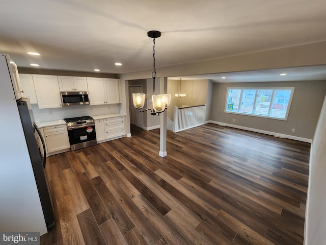 kitchen featuring light countertops, hanging light fixtures, an inviting chandelier, appliances with stainless steel finishes, and white cabinets