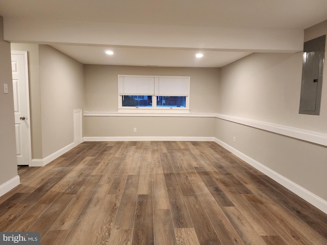 finished basement with recessed lighting, wood finished floors, electric panel, and baseboards