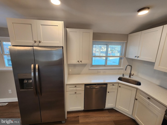 kitchen with a sink, visible vents, white cabinetry, light countertops, and appliances with stainless steel finishes