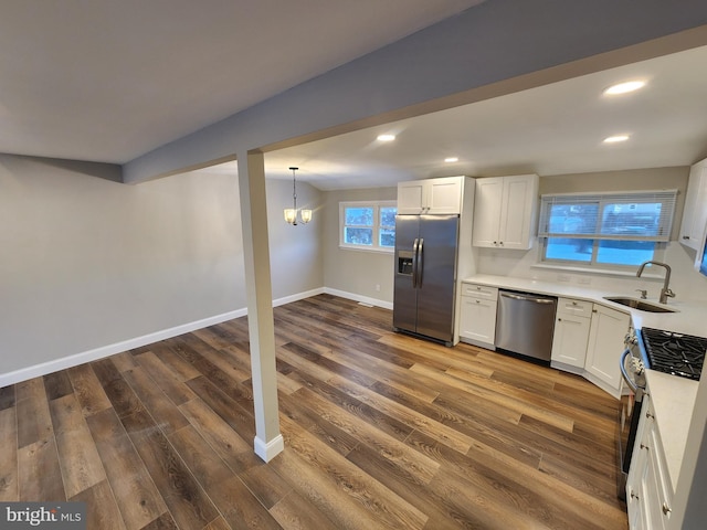 kitchen featuring light countertops, appliances with stainless steel finishes, a sink, and white cabinetry