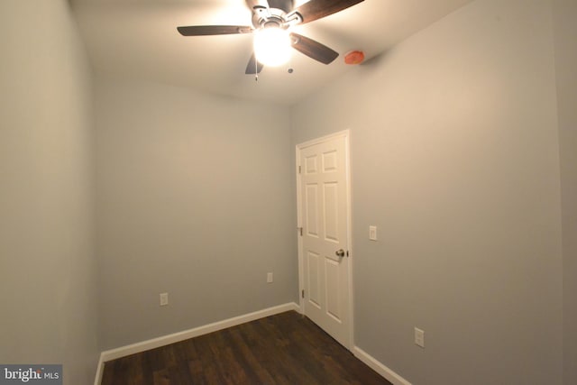 empty room with dark wood-type flooring, baseboards, and a ceiling fan