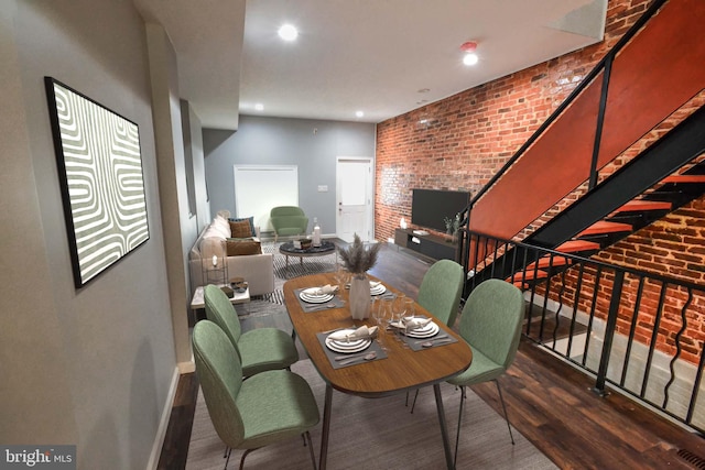 dining space with recessed lighting, brick wall, baseboards, stairway, and dark wood finished floors