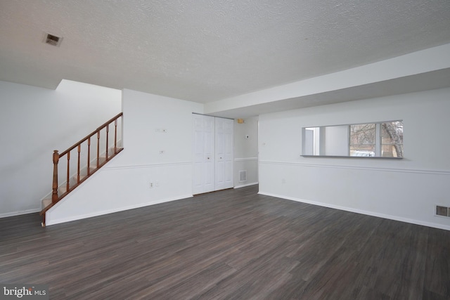 unfurnished living room with stairway, wood finished floors, visible vents, and baseboards