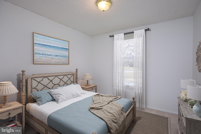 carpeted bedroom with a textured ceiling and baseboards