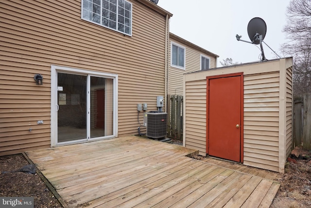 deck with an outdoor structure, a storage shed, and central AC unit