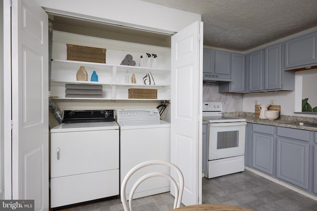 clothes washing area featuring a sink, laundry area, washer and clothes dryer, and a textured ceiling