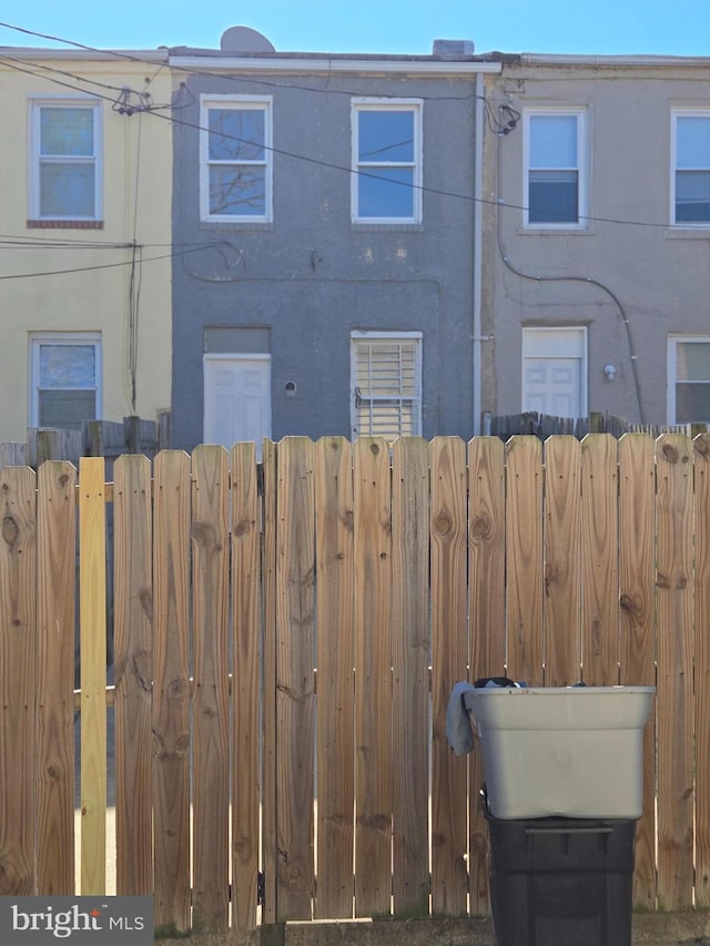 back of house with stucco siding and fence