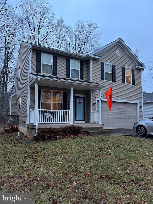 traditional-style house with covered porch, a front lawn, an attached garage, and aphalt driveway