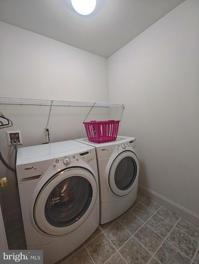 washroom with laundry area, baseboards, and separate washer and dryer