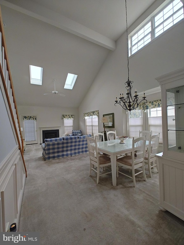 unfurnished dining area with beamed ceiling, a wealth of natural light, and light colored carpet