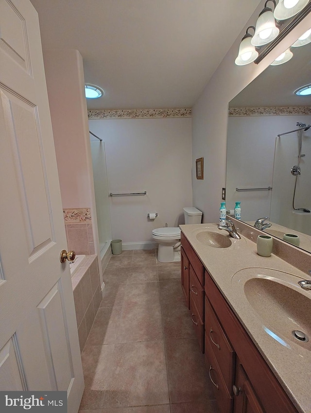 full bathroom with double vanity, tile patterned flooring, toilet, and a sink