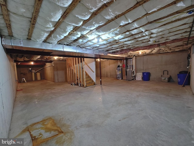 unfinished below grade area with gas water heater, heating unit, and stairs