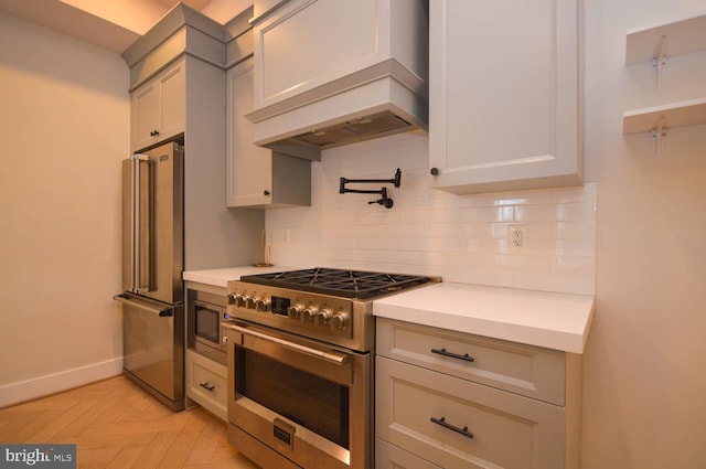 kitchen featuring high quality appliances, baseboards, light countertops, backsplash, and custom exhaust hood